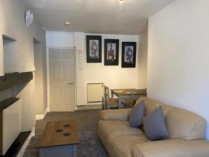 a living room with a couch and a table at Rosecraddoc Manor - Coachman's in Saint Cleer