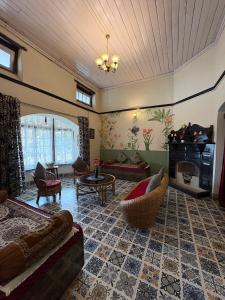 a living room with a couch and a table at Rose Villa Colonial Heritage Bungalow, Takdah in Takdāh