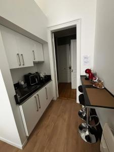 a small kitchen with white cabinets and a counter top at Les Cariatides in Lille