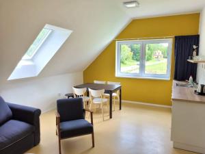 a living room with a table and chairs and a window at Apartmány U Jeskyní in Sloup