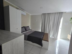 a bedroom with a bed and a large window at Residencial New Stilo-Falésia in Canoa Quebrada