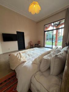 a large white bed in a room with a window at Royal Moroccan House in Marrakesh