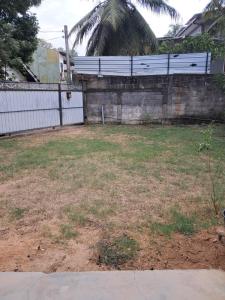 an empty yard with a fence and a wall at Home stray 7 in Matara