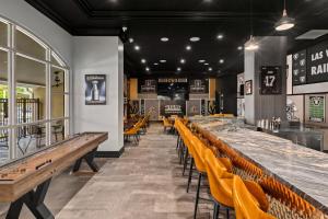 a restaurant with a long bar with yellow chairs at Club Wyndham Grand Desert in Las Vegas