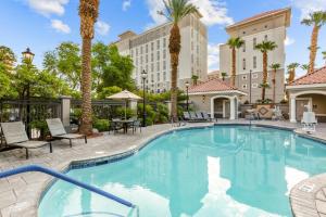 a swimming pool with palm trees and a hotel at Club Wyndham Grand Desert in Las Vegas