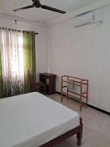 a bedroom with a bed and a table and chairs at Home stray 7 in Matara