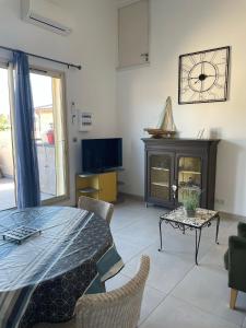 a living room with a table and a tv at St Cyprien beau T3 entre mer et village in Saint-Cyprien