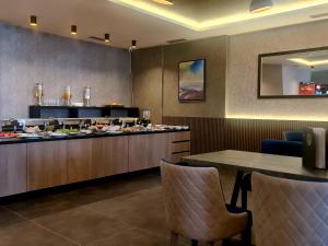 a restaurant with a buffet with a table and chairs at RELAX RESIDENS-kopaonik in Kopaonik