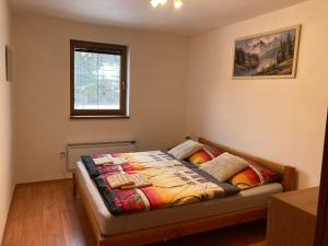 a bedroom with a bed with a quilt on it at Apartmán pod kopcom in Telgárt
