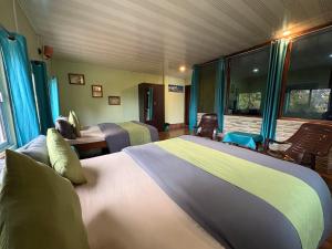 a bedroom with two beds in a room at Rose Villa Colonial Heritage Bungalow, Takdah in Takdāh