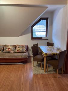 a living room with a table and chairs and a bed at Apartmán pod kopcom in Telgárt