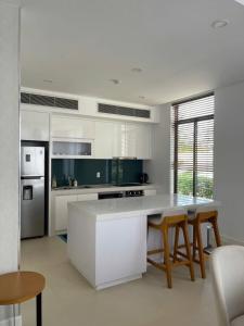 a kitchen with white cabinets and a table and chairs at Wyndham garden villa 304 in Cam Lâm