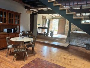 a living room with a table and a stone fireplace at Golindo Goikoa in Getaria