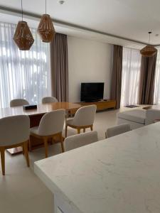 a living room with a table and chairs and a television at Wyndham garden villa 304 in Cam Lâm