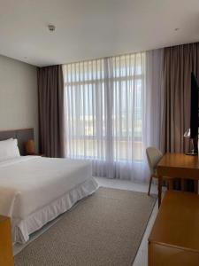 a hotel room with a bed and a desk and window at Wyndham garden villa 304 in Cam Lâm +24 photos