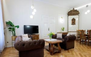 a living room with two couches and a tv at Zakątek Żywiecki in Żywiec