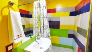 a colorful bathroom with a sink and a shower at City Hotel Shymkent in Shymkent