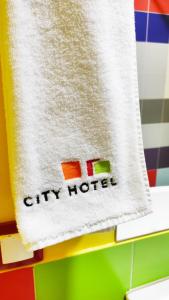 a city hotel towel hanging on a wall at City Hotel Shymkent in Shymkent