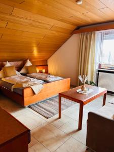 a bedroom with a large bed and a table at Hotel Garni Sebastian in Kirrweiler