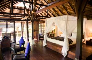 a bedroom with a bed with a mosquito net at Koyao Bay Pavilions - SHA Extra Plus in Ko Yao Noi