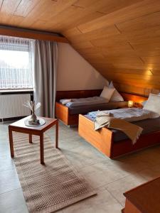 a room with two beds and a table in it at Hotel Garni Sebastian in Kirrweiler