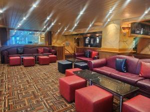 a waiting room with red couches and tables at The Heritage Hotel in Torquay