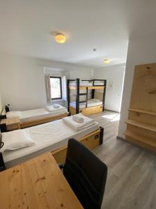 a dorm room with three bunk beds and a chair at AMAZIGH HOSTEL Ensuite Rooms & Dorms with shared Kitchen in Aljezur