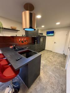 a kitchen with a sink and a red stool at Ferienwohnung Könitz, Ilschen in Naumburg