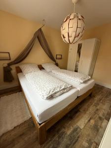a bedroom with a bed with a canopy and a chandelier at Ferienwohnung Könitz, Ilschen in Naumburg