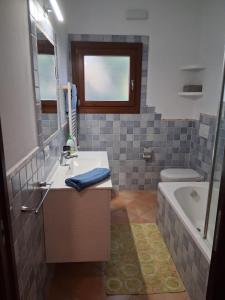 a bathroom with a sink and a tub and a toilet at Casamare Roby in Tanaunella