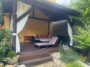 a wooden deck with a couch and a table at Zakątek Żywiecki in Żywiec