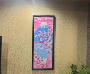 a framed picture of flowers on a wall at HOTTOSTAYKiyosu in Nagoya