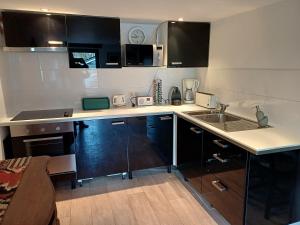 a kitchen with black and white cabinets and a sink at Lozerhof Studio in Kruisem