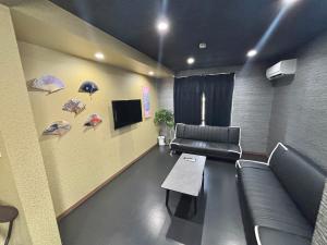 a waiting room with a couch and umbrellas on the wall at HOTTOSTAYKiyosu in Nagoya