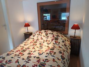 a bed with a blanket with birds on it at Lozerhof Studio in Kruisem
