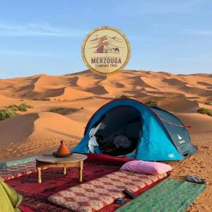 a tent and a table in the desert at Erg Chebbi Nomad Camp in Merzouga