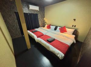 a bedroom with a large bed with red pillows at HOTTOSTAYKiyosu in Nagoya