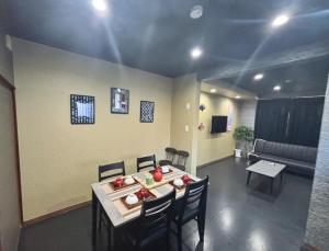 a living room with a table and chairs and a couch at HOTTOSTAYKiyosu in Nagoya