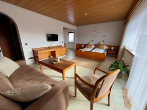 a living room with a couch and a table at Hotel Garni Sebastian in Kirrweiler