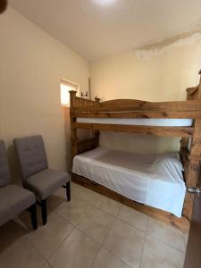 a bedroom with a bunk bed and a chair at 20 minutes from Chapala, Pool &Grill in Buenavista +9 photos