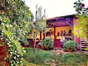 a small yellow house with a yard with trees at Veliki Banjan in Riznica Kraj +156 photos