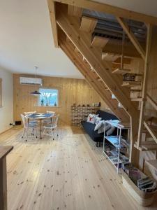 a living room with wooden floors and a wooden staircase at Astroturystyka Izeria in Leśna