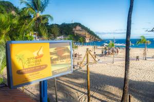 a sign on a beach with people on the beach at Brisa do Caitá Praia Hotel in Morro de São Paulo +45 photos