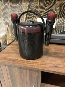a black slow cooker sitting on a table with two microphones at 786 Bali Top Homestay in Sungai Petani