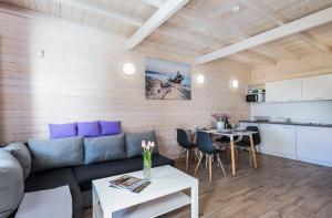a living room with a couch and a table at Wrzosowy Zakątek Sarbinowo in Sarbinowo