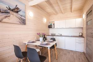 a kitchen and dining room with a table and chairs at Wrzosowy Zakątek Sarbinowo in Sarbinowo