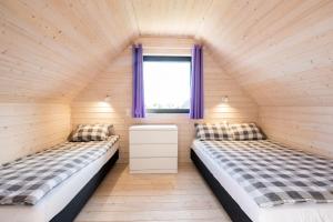 two beds in a small room with a window at Wrzosowy Zakątek Sarbinowo in Sarbinowo +16 photos
