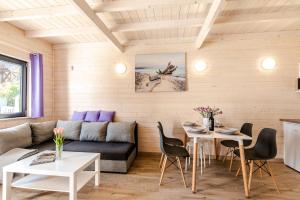 a living room with a couch and a table at Wrzosowy Zakątek Sarbinowo in Sarbinowo