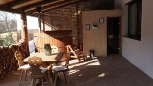 a patio with a table and chairs and a door at Lomb Lak Vendégház in Kozármisleny