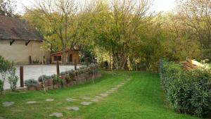 a yard with a house and some trees and a yard sidx sidx sidx at Lomb Lak Vendégház in Kozármisleny